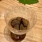 やまぐち - ❷干し貝柱の出汁ゼリー ～大きな葉に隠れた干し貝柱の出汁にスライスした干し海鼠とナガノパープル、焼き茄子を添えた一品。干し貝柱のだしのゼリーとナガノパープルという果実を上手く使った料理が夏らしい。