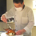 眞善美 - コンガリとあめ色に焼きあがった北京ダックを調理する河合シェフ。