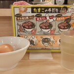 Nikujirumen Susumu - 空いていたカウンター席へ座り、食券をスタッフさんへ。入口脇にしかない？セルフ対応の水汲みに行ってまもなく「たまご」が支給されました。