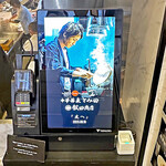 Japanese Soba Noodles 蔦 - 階段下の券売機には、在りし日の祐貴さんの映像と「Japanese Soba Noodles 蔦 × 中華蕎麦 とみ田 × らぁ麺屋 飯田商店 【友へ】 」2023.09.19と有ります