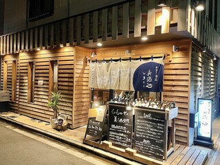 Tsukishima Kuimonoya Bisutoko - 木目調の温もりある外観。入り口にずらっと並んだワインボトルは、見ているだけでもワクワクします。