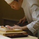 くるますし - 人を切るのが上手なオジサンの写真を拝借。 この大将独特のスタイルの切りつけ方。 サワラです。