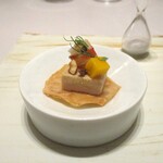 レミニセンス - フォアグラ：フォアグラのテリーヌの下には板状にしたジャガイモのフリット、上には車海老、マンゴー、ナッツ　etc．にフェンネルが飾られています。こちらも手に取っていただきます。 70秒分の白い砂が入った砂時計と共に お料理は提供されます。フォアグラの濃厚な味わいを砂時計の砂が落ちきるまで楽しみます。  そして・・・、余韻を残しつつ 次のお料理をいただきます。