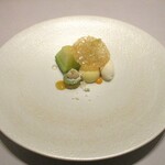 レミニセンス - 天使音メロン：浜松の天使音メロン（アマネ）を中心に、抹茶ソースのメレンゲ、ホワイトチョコレートに包まれたメロンのソース、バニラアイスが並び、薄い板状のカラメルが飾られています。 球体のホワイトチョコの真ん中にナイフを入れ 半分に割ると、中からメロンのソースがトロォ～リと流れ出ます。