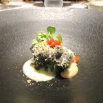 レミニセンス - 鱧：鱧切包丁で丁寧に骨切りした鱧に 海苔の衣をつけて揚げてあり、上からコンテチーズがタップリと振りかけられ、下にはキャベツのソテーが敷かれています。①アーモンドピューレ、② トマトソース、③ 24ヶ月熟成した濃厚なコンテチーズ のソース、 ３種のソースでいただきます。 黒い鱧が印象的で香り立つ とても見事なお料理です！