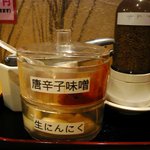 麺酒屋 蛸料理 一龍亭 - 壁の方を見ると、唐辛子味噌、生にんにく、すりごまが置いてありました。