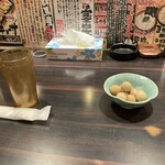 環七ラーメン 周麺 - おしぼりと空のプラスチックグラスにウズラの醤油漬け