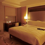 インターコンチネンタルホテル大阪 - ベッドルームの窓際には、無線ラン、ランケーブルを備えた機能的なパソコンデスクがあり、ベッドの上には色違いの浴衣風夜着が置いてあります。。