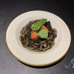 Squid ink pasta with spear squid, fruit tomatoes and basil