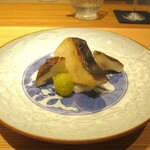 好日 - 焼物：鰆の下には、裏ごした ゆり根が敷かれ、玉取茸、揚げた新銀杏 が添えられています。