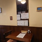 ビストロ コゥジィ - テーブル席の壁には、営業案内とメニューが貼られています。