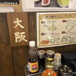 肉汁水餃子餃包 - 席毎に掲示。ここは大阪。隣は外国語？ほかどうなってんだろう…？