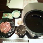 圓石 本店 - 調理前の石鍋と肉とおっぱいプリンに見えるコラーゲンボールとニンニクとタマネギとネギ