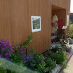 ダ・ルイジ - 店舗入口の花壇。色とりどりの花を見ながら開店を待つ。海風を受け、花々がせわしなさそうに揺れていた。