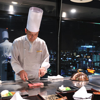 最上階の眺めを楽しみながら、目の前で魚介類や最上質の牛肉を焼き上げます