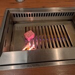 焼肉うしごろ - 鉄板の上で、厚切りサーロインを焼く様子です。