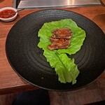 焼肉うしごろ - サンチュの上にのせた、鉄板で焼いた後の極みのタン２枚（赤味噌付き。）です。