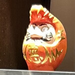 プロント - カウンター席の棚にリーゼントダルマ 悪と書いてある。何を願って目を書くか？謎。