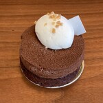 Un Petit Paquet - シブーストショコラキャラメル　チョコレートタルトに、キャラメルがけのヘーゼルナッツを入れ チョコレートのシブーストクリームを重ねたケーキ