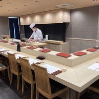 鮨 天ぷら 祇園いわい - 店内風景(カウンター)。他に個室がいくつかある。椅子が出ているのが今回の席で一旦座ってから再度立って撮影した。席にある黒いものがドリンクメニュー。全てコースなので寿司メニューはない。