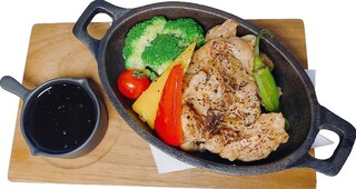 KUJIRA - 漬け込んだ鶏もも肉と野菜を炒めて熱いプレートにのせました。KUJIRAオリジナルソースをかけて召し上がってください。プレートは熱いのでやけどに気をつけてください。