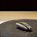 くるますし - コハダ。 脂の多い、濃いタネが続いたあとにこれです。 江戸前でのコハダのポジションは、全く逆で、脂の多いタネの前に出すことが多いですが、僕は脂を落とすこの流れのほうが好きです。 味覚がしゃきっとします。 このポジションの理由は、このあとの流れからも正しい選択だと思いました。 それにしても、しっかり締めてあって、酢がしっかり表に出るこの店のシャリとともに、背筋が伸びるような旨いコハダ。