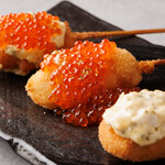 Set of two creative skewers made with the treasure of the sea, salmon roe and caviar