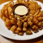 OUTBACK STEAKHOUSE - お店の売りのひとつ、ブルーミンオニオン(オニオンリング)です。やや甘めのソースとの相性、絶品でした♪