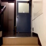 コトカフェ - 雑居ビルの2階にあります。こんな鉄の無機質なドアの窓枠のところにある名刺が目印。