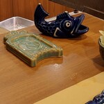 Ginza Isomura - 串揚げ提供される時に受けるお皿と
      串差し（お魚の置物みたいなの）⬅カウンター席のみ
      　　　　　　　　　　（テーブル席は普通の串刺入れです。）