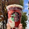 スターバックス・コーヒー - 秋の街路樹を背にした「ストロベリー メリークリーム フラペチーノⓇTall」