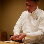 鮨 十兵衛 - 詰め襟の割烹着姿はどこかコック服を身に纏ったフレンチシェフのような佇まいと所作で魅力する塚田氏。
