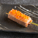 Rare salmon grilled skewer topped with salmon roe
