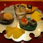 おおたに - 八寸：①宮崎牛イチボと帆立貝のフライ。鬼おろしポン酢でいただきます。宮崎牛イチボと帆立貝柱のフライはレア感満載でとても良いですネ！　②いくら寿司。うえにポッチリと山葵がのっています。　③春菊の白和え。うえには真っ赤なクコの実が飾られているのが印象的です。　④牡蠣と下仁田ねぎの味噌焼き。仕上げに味噌の上からバーナーで焼きあげてあります。　⑤鮭と牛蒡の東寺巻き。ガラスの器に盛られています。