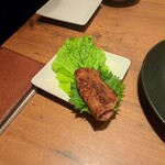 焼肉うしごろ - 網の鉄板で焼いた栃木県産黒毛和牛A5リブロースを、サンチュ1枚と大葉2枚の上にのせた様子その1です。