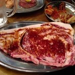 大阪焼肉・ホルモン ふたご - 圧巻の名物黒毛和牛のはみ出るカルビ