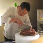 眞善美 - 北京ダック：こんがりとあめ色に焼かれた大きな北京ダックを シェフが目の前で手際よく 皮の旨み部分を極限まで薄く削いでいきます。 皮から滴り落ちる綺麗な脂分も見ているだけで食欲をかき立てられますネ！