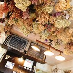 フランクリンズカフェ - 繊細なビンテージのトーンのドライフラワーで飾られたカウンター前