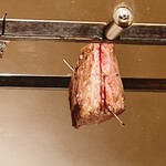 温石 - ゆっくりと遠火の炭で炙られる知床牛のシンタマ。脂の雫が炭に落ちて、ジュワッ、と白い煙が立ち昇ります