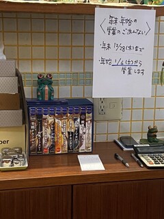 かえる食堂 - 調理場後ろに何故か他社のレトルトカレーの箱が。何故か不思議。