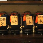 旬彩 天ぷら 心来(しんら） - カウンターの中に並ぶ焼酎の甕。