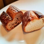 レストラン ヴァリエ - 手前のバゲットはきめ細かくほんのりミルクの甘味、奥はザクッと香ばしく力強い粉の風味が印象的な全粒粉のパン