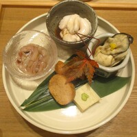 奥 - 先付：①真鱈 白子、新鮮でプルンとした食感と濃厚なお味が良いですネ！ ②広島産 牡蠣の湯引きを柚子風味でいただきます。 ③烏賊の塩辛。 ④ホタテの燻製はスモークが効いたチーズにも似たお味です。 ⑤鱈子の煮付け。 ⑥蟹味噌豆腐に山葵トッピング。