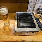 Tachigui Yakiniku Jiroumaru - カウンターの生ビールとロースター