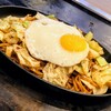 Okonomiyaki Tsunagu - 焼きそばは、中太麺でキャベツが大量に入っており、半熟の目玉焼きが乗っている
                （豚肉とイカは2切れずつと淋しめ）