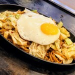 お好み焼 つなぐ - 焼きそばは、中太麺でキャベツが大量に入っており、半熟の目玉焼きが乗っている
（豚肉とイカは2切れずつと淋しめ）