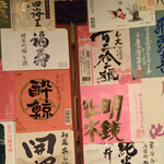 大納言本家 - 店内に貼られている日本酒ラベルの一部