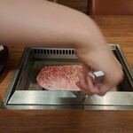 焼肉うしごろ - 網の鉄板で、鹿児島県産のA5黒毛和牛大判サーロインを焼く様子のその1です。