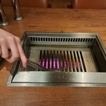 焼肉うしごろ - 網の鉄板に、牛脂を塗る様子です。