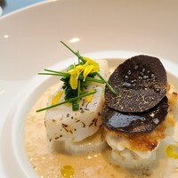 ナベノ-イズム - ⑩塩鱈を50℃の油で20分茹でるコンフィ、湯引きした白子の鉄板焼きの双子載せ、千寿葱敷き、クレーム・ド・パルメザンのソース、黒トリュフ(フランス産)載せ、大蒜の芽の爆(油掛け)載せ、菊花を散らして